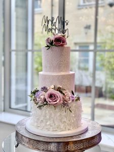 Iced Wedding Cake with purple lilac lace white ruffles fresh flowers topper stencil