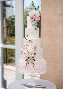 Pink iced wedding cake ruffles sugar flowers 5 tier roses marble romantic tall classic elegant