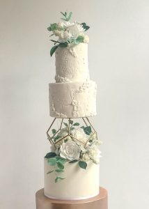 Textured iced wedding cake with bass relief detail and sugar flowers