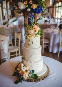 Iced wedding cake with royal icing piping floral details and fresh flowers