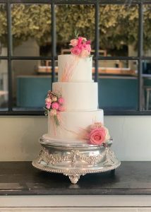 Iced wedding cake with fresh flowers and royal icing details